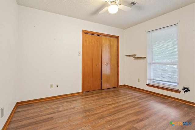 3927 Amanda Dr, Salado, TX 76571 - unfurnished bedroom with wood finished floors, a closet, ceiling fan, and a textured ceiling