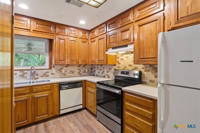 3927 Amanda Dr, Salado, TX 76571 - kitchen featuring white appliances, under cabinet range hood, light countertops, backsplash, and a textured ceiling