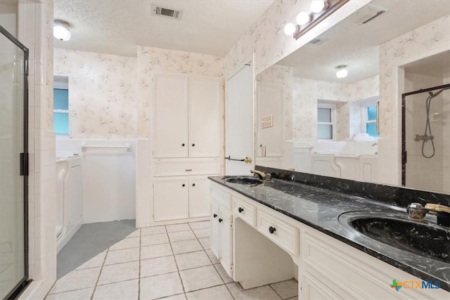 3927 Amanda Dr, Salado, TX 76571 - full bath with wallpapered walls, a shower stall, a textured ceiling, tile patterned flooring, and double vanity