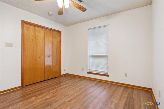 3927 Amanda Dr, Salado, TX 76571 - unfurnished bedroom featuring wood finished floors, a closet, ceiling fan, and a textured ceiling