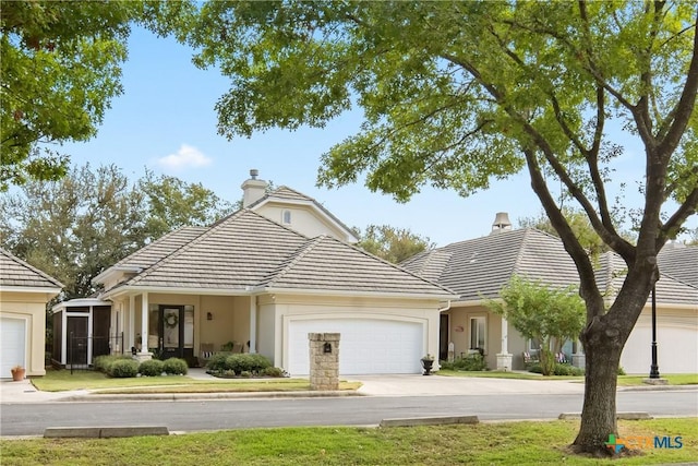 view of front of house with a chimney, concrete driveway, and a tiled roof