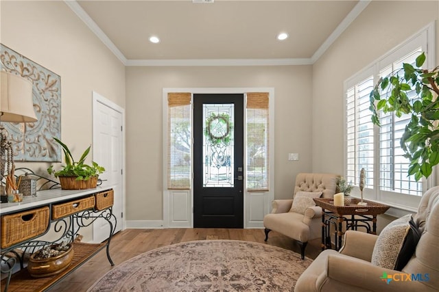 foyer entrance featuring light wood finished floors, baseboards, ornamental molding, and recessed lighting