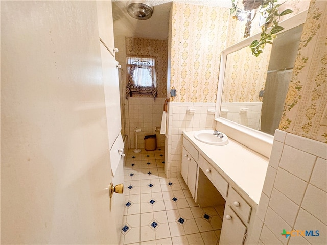 bathroom with tile walls, vanity, and tile patterned floors