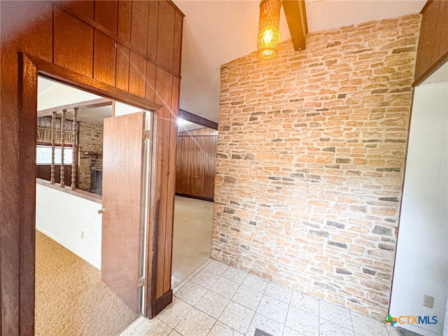 corridor featuring beamed ceiling and light colored carpet