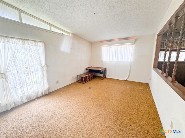 carpeted empty room featuring a textured ceiling