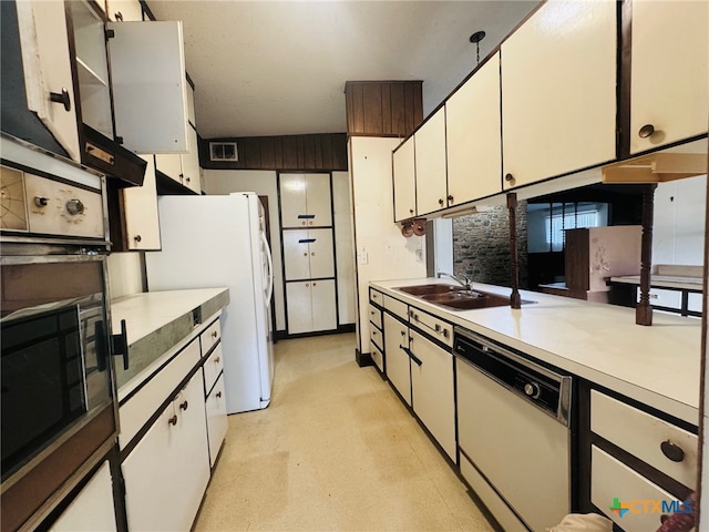 kitchen with white appliances, sink, and white cabinets