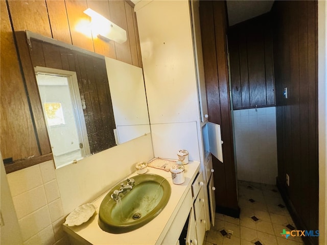 bathroom featuring vanity, tile patterned floors, and tile walls