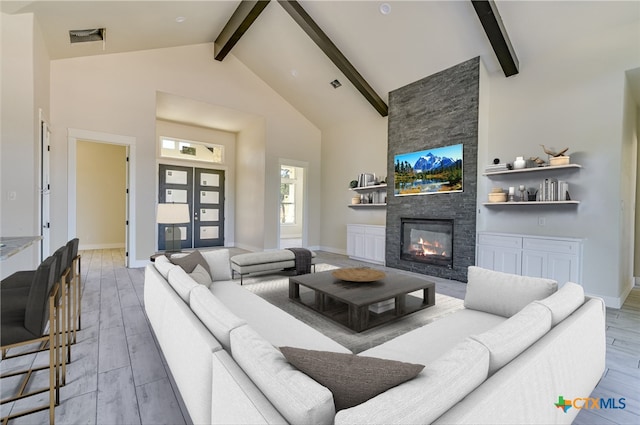 living room featuring french doors, beam ceiling, high vaulted ceiling, light hardwood / wood-style flooring, and a fireplace