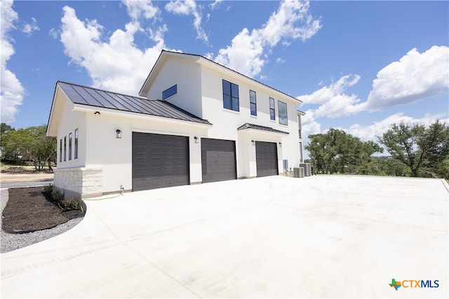 view of side of property with central air condition unit and a garage