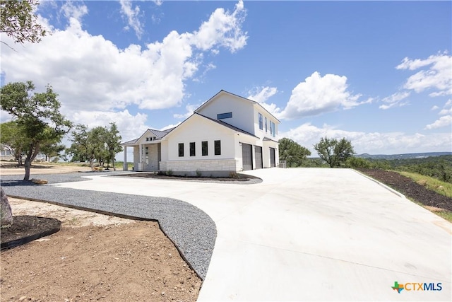 1193 Country Pike, Canyon Lake, TX 78133 - view of front of house featuring an attached garage, curved driveway, stucco siding, and stone siding
