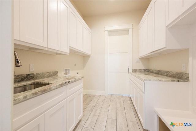 1193 Country Pike, Canyon Lake, TX 78133 - kitchen with white cabinets, light wood-style flooring, and light stone countertops