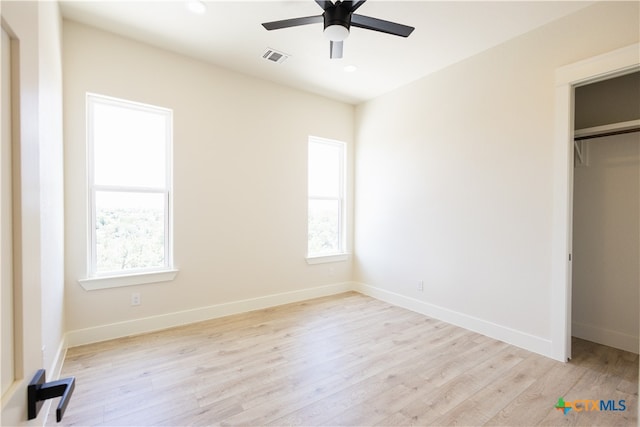 unfurnished bedroom featuring ceiling fan, light wood-type flooring, and a closet