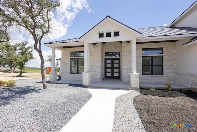 1193 Country Pike, Canyon Lake, TX 78133 - doorway to property featuring a standing seam roof, a metal roof, stone siding, and covered porch