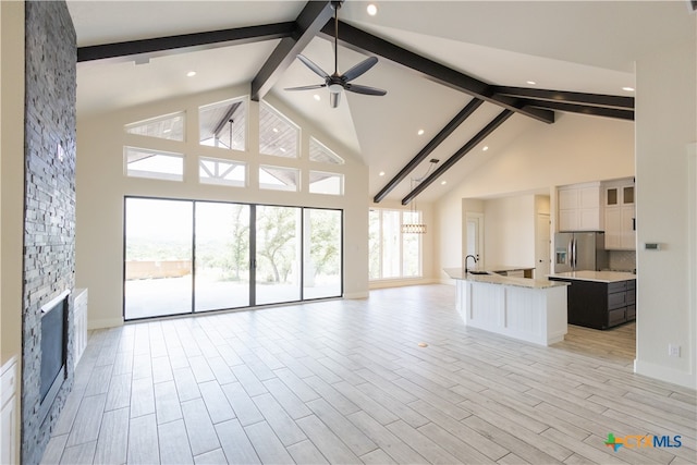 unfurnished living room with light hardwood / wood-style flooring, high vaulted ceiling, and a wealth of natural light