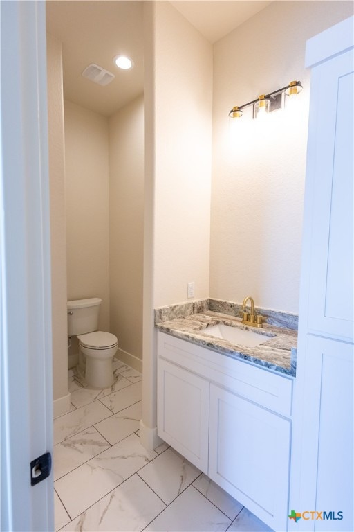 bathroom featuring vanity and toilet