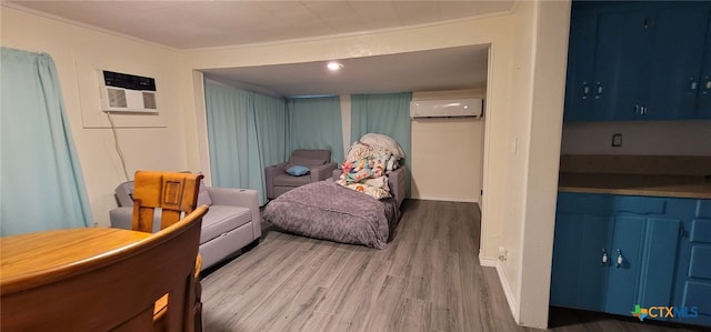 302 E Dallas Ave, Seadrift, TX 77983 - living area featuring a wall mounted AC, wood finished floors, a wall mounted air conditioner, ornamental molding, and baseboards