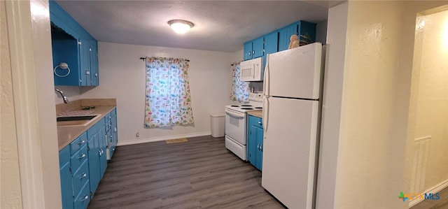 302 E Dallas Ave, Seadrift, TX 77983 - kitchen with blue cabinets, white appliances, a sink, and dark wood-style floors