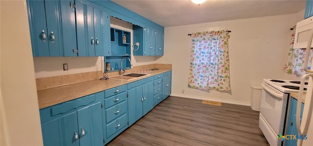 302 E Dallas Ave, Seadrift, TX 77983 - kitchen featuring electric range, a sink, blue cabinets, and dark wood-style flooring