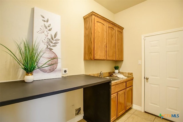1127 Chaucer Ln, Harker Heights, TX 76548 - kitchen featuring light tile patterned floors, brown cabinetry, and dark countertops