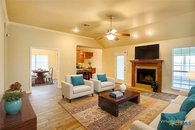 1127 Chaucer Ln, Harker Heights, TX 76548 - living room featuring light wood finished floors, ornamental molding, a tiled fireplace, a ceiling fan, and vaulted ceiling