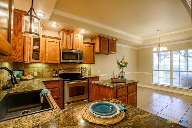 1127 Chaucer Ln, Harker Heights, TX 76548 - kitchen featuring appliances with stainless steel finishes, backsplash, a raised ceiling, brown cabinetry, and crown molding