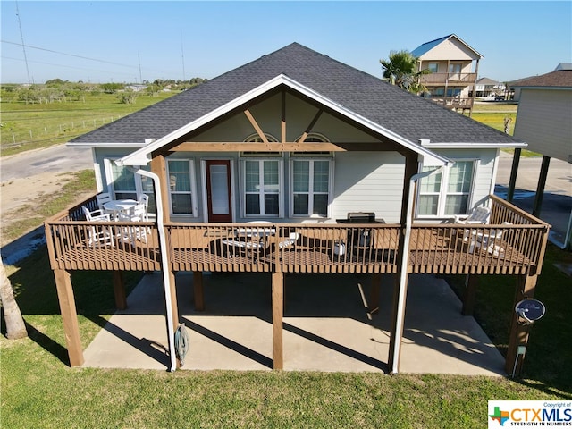 back of property with a wooden deck and a yard