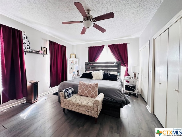 bedroom with dark wood-type flooring, ceiling fan, and a textured ceiling