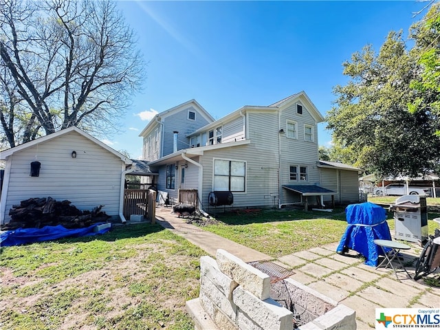 back of property featuring a patio area and a yard