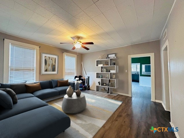 living room with ceiling fan, dark hardwood / wood-style flooring, and ornamental molding