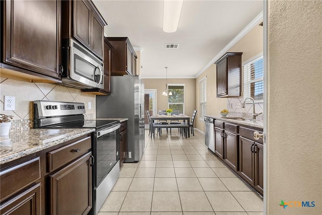 1103 Sugar Brook Dr, Temple, TX 76502 - kitchen featuring stainless steel appliances, crown molding, decorative backsplash, dark brown cabinets, and light stone countertops