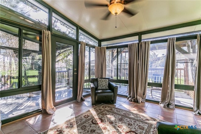 unfurnished sunroom with ceiling fan, a healthy amount of sunlight, and lofted ceiling