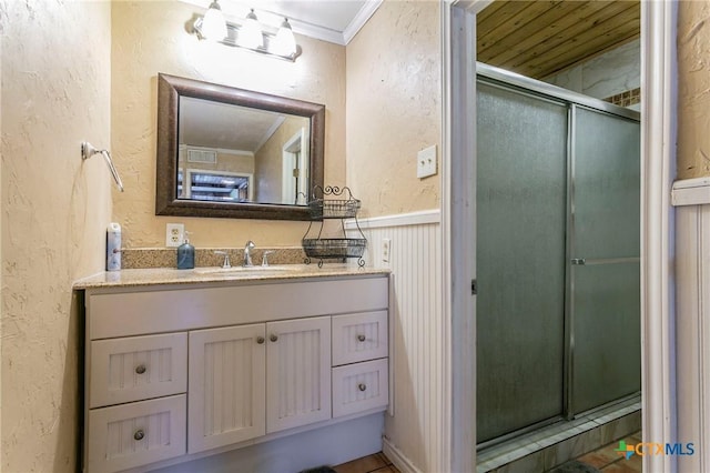 bathroom featuring vanity, ornamental molding, and walk in shower