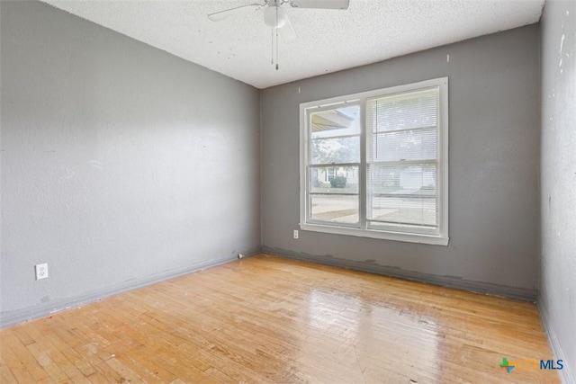 unfurnished room featuring baseboards, a textured ceiling, ceiling fan, and wood finished floors