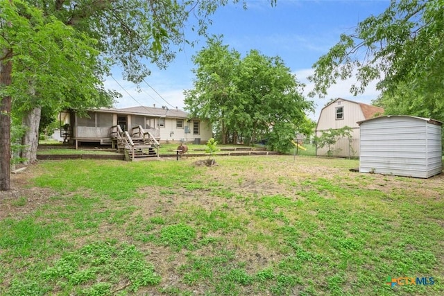 view of yard featuring a storage unit, an outdoor structure, and a sunroom