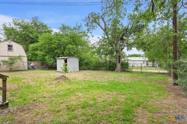 view of yard with a fenced backyard, a shed, and an outbuilding
