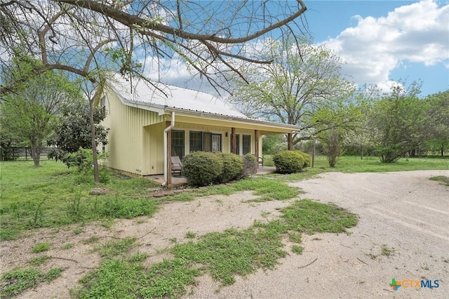 420 Mill Rd, Maxwell, TX 78656 - view of home's exterior with a yard, metal roof, and covered porch
