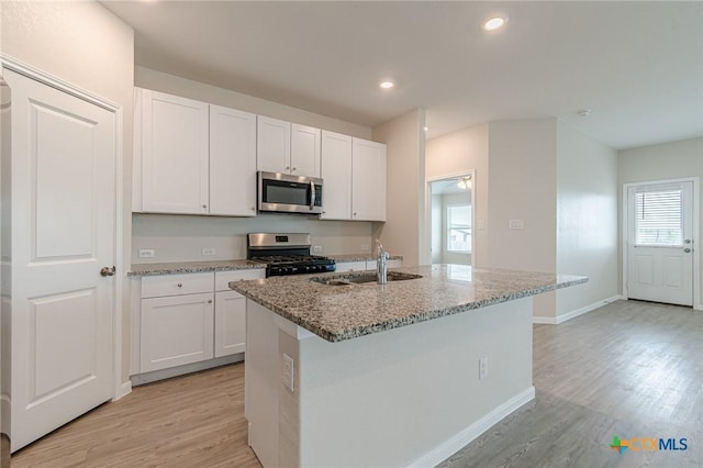 2824 Green Finch, New Braunfels, TX 78130 - kitchen with appliances with stainless steel finishes, light stone counters, light wood-style flooring, white cabinetry, and recessed lighting