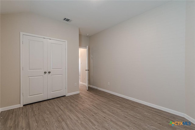 2824 Green Finch, New Braunfels, TX 78130 - unfurnished bedroom featuring wood finished floors, baseboards, a closet, and vaulted ceiling