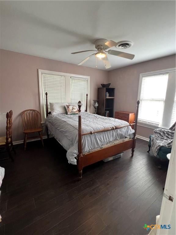 bedroom featuring baseboards, a ceiling fan, wood finished floors, and visible vents