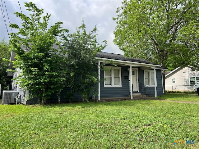 bungalow-style home with fence, central AC unit, and a front yard