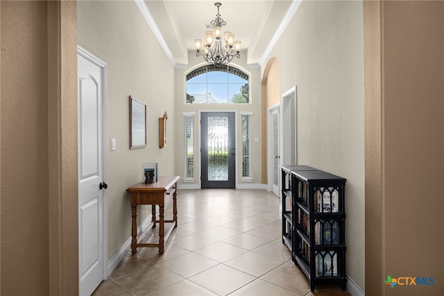 959 Wilderness Trl, New Braunfels, TX 78132 - entryway with a chandelier, crown molding, light tile patterned floors, baseboards, and arched walkways
