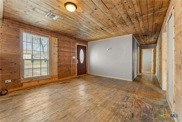 foyer entrance featuring wooden walls, hardwood / wood-style flooring, and wood ceiling