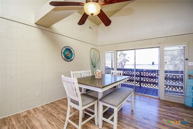 dining room with hardwood / wood-style floors, a high ceiling, and ceiling fan