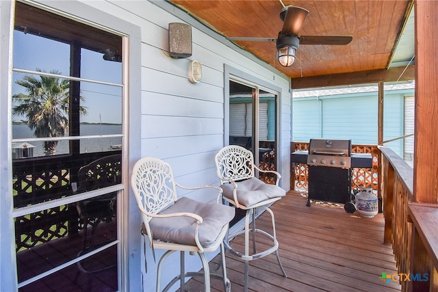 wooden terrace featuring area for grilling and ceiling fan