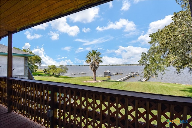 deck with a water view, a lawn, and a boat dock