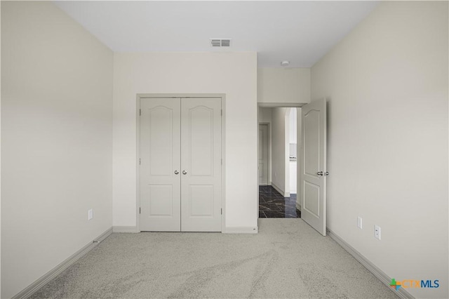 unfurnished bedroom featuring carpet flooring and a closet