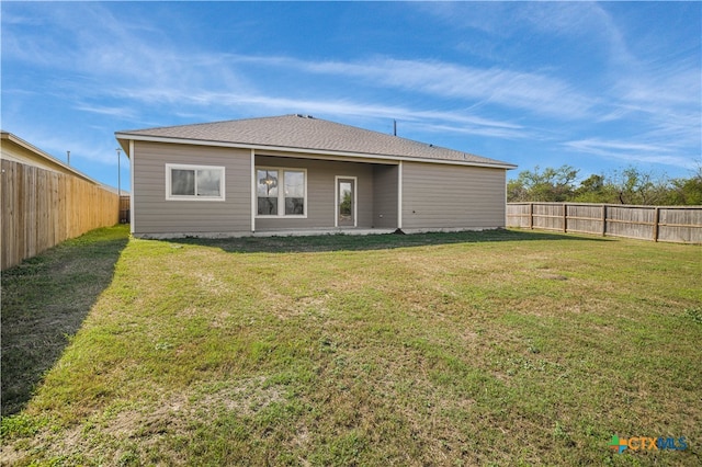 rear view of property with a yard