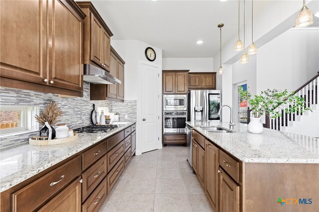3437 De Soto Loop, Round Rock, TX 78665 - kitchen featuring appliances with stainless steel finishes, under cabinet range hood, decorative backsplash, a sink, and light stone counters