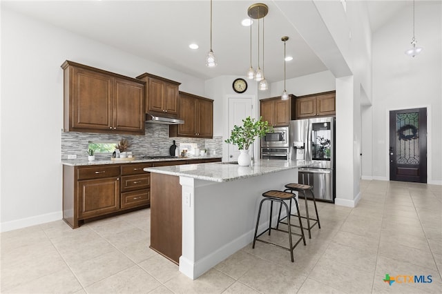 3437 De Soto Loop, Round Rock, TX 78665 - kitchen with stainless steel appliances, under cabinet range hood, tasteful backsplash, light tile patterned floors, and recessed lighting