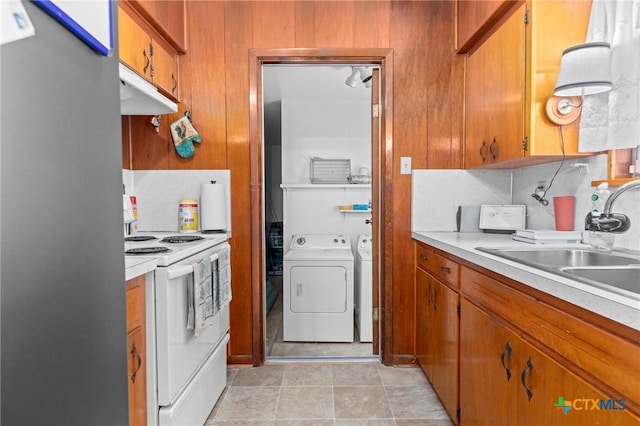 kitchen with white electric range oven, decorative backsplash, separate washer and dryer, and sink